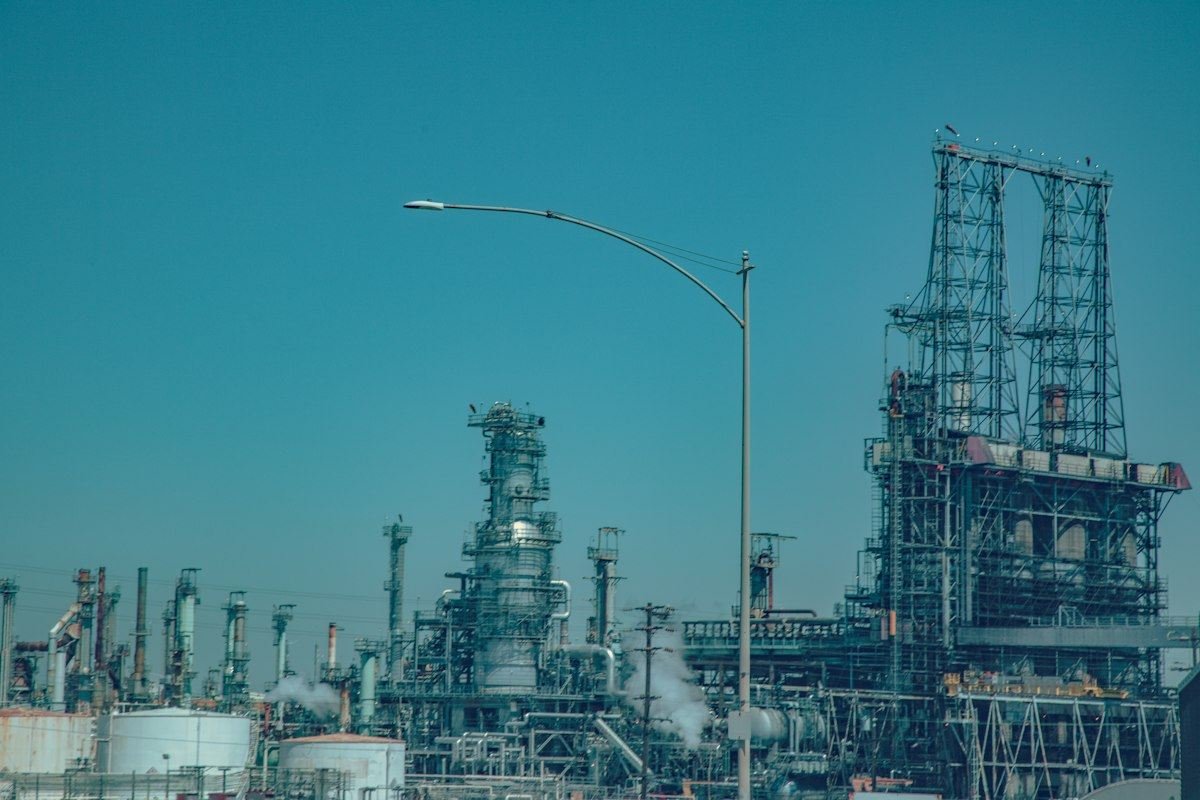 Industrial oil refinery complex under a clear blue sky