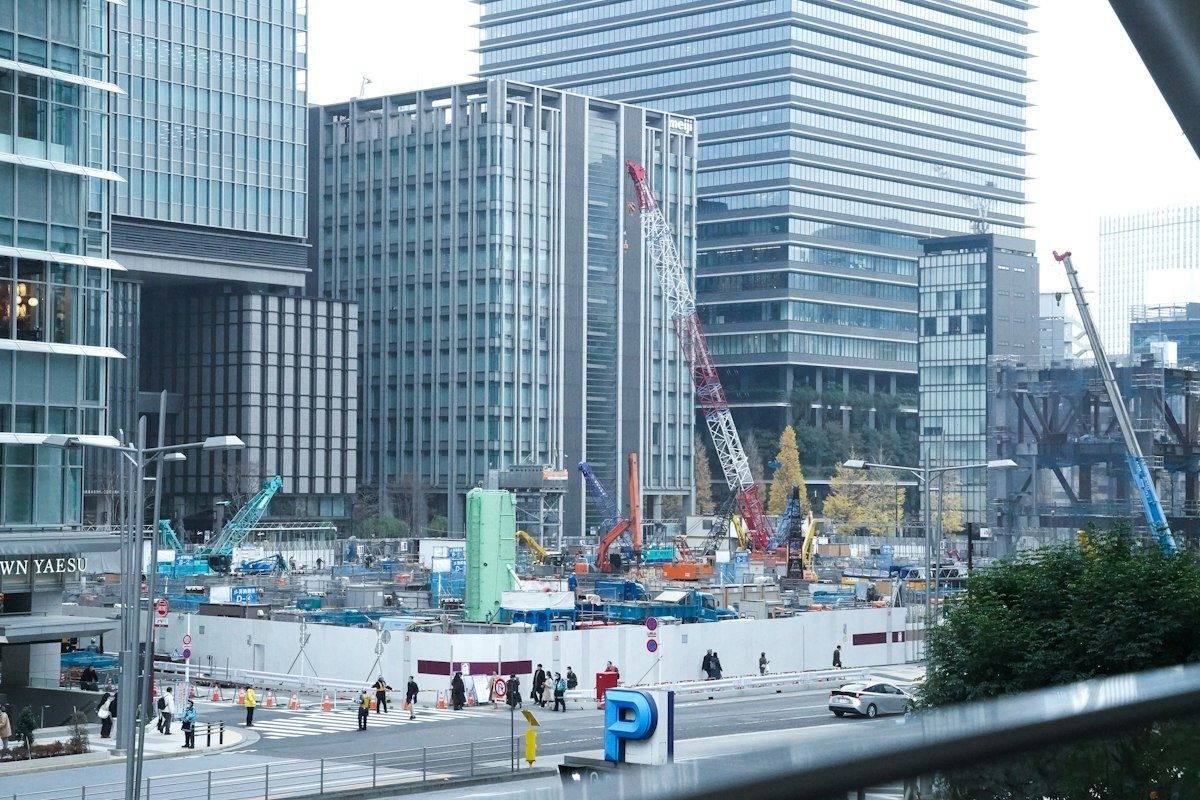 Construction site with cranes and buildings in the background