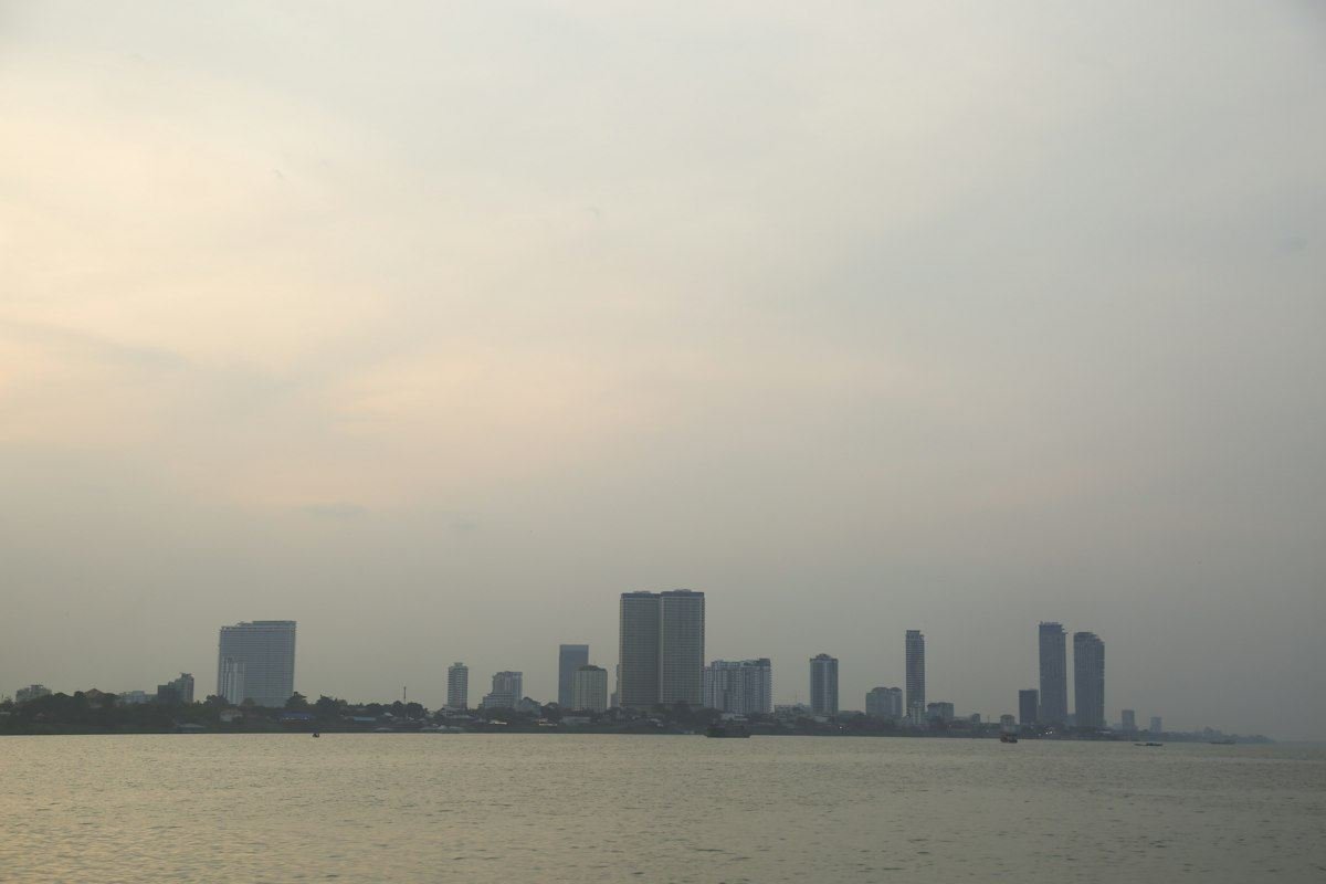 City skyline across water under a hazy sky