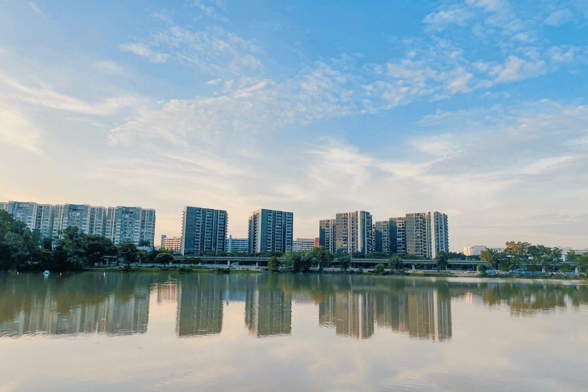 city skyline across body of water under blue and white sunny cloudy sky during daytime