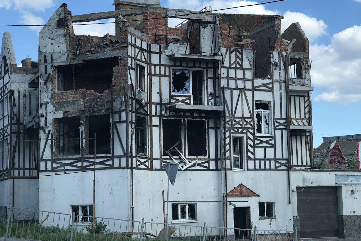 Damaged building with broken windows and exposed brick