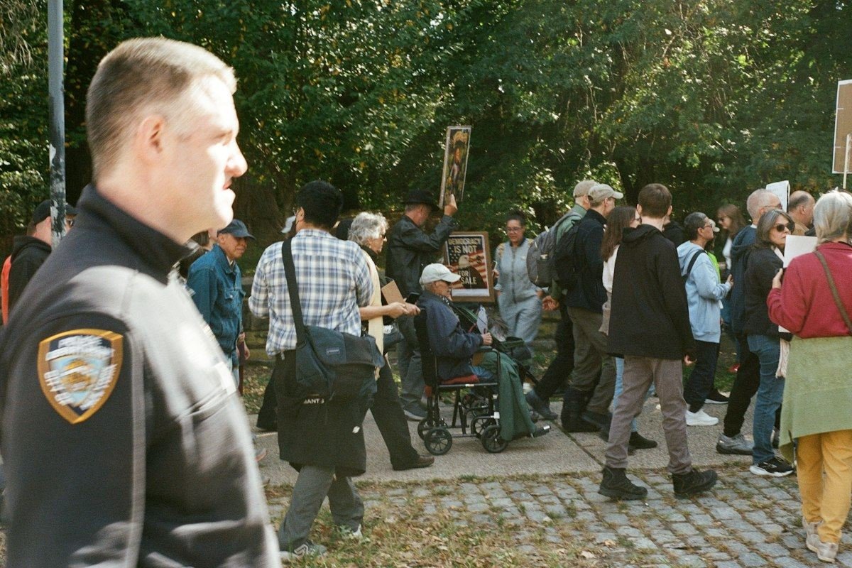 Police officer watches a protest march with signs