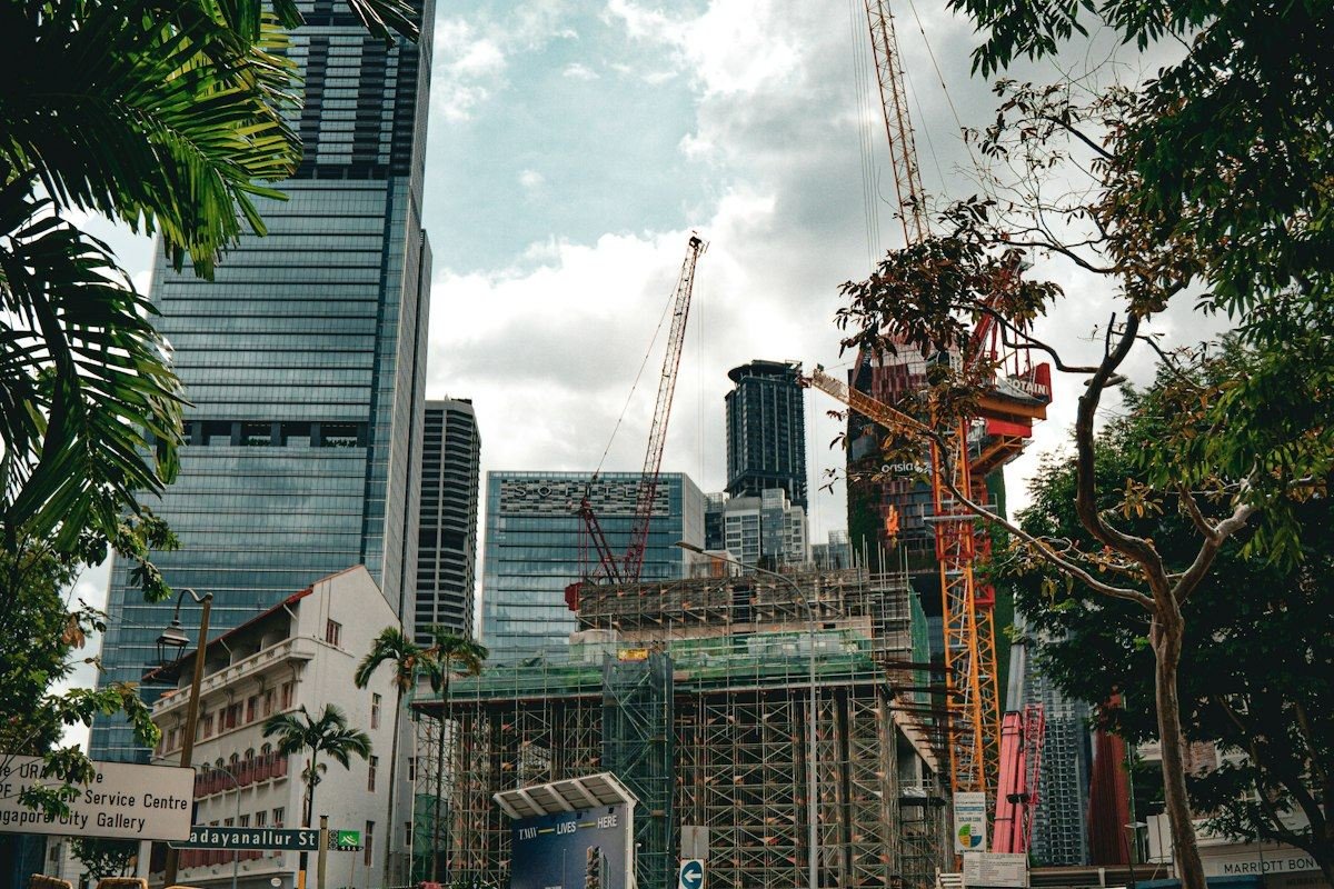 City construction site with cranes, tall buildings, and workers