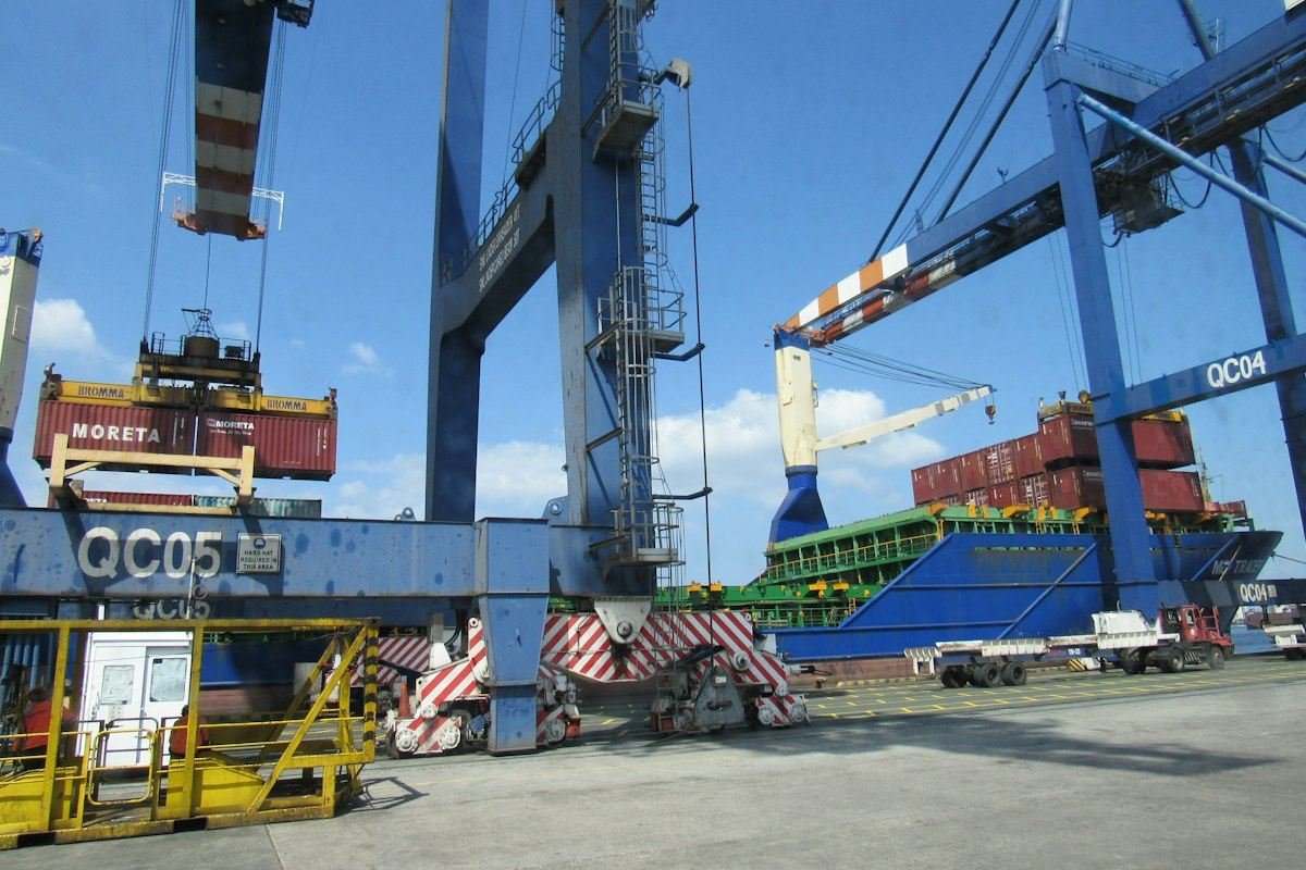Container ship being loaded by large cranes at port