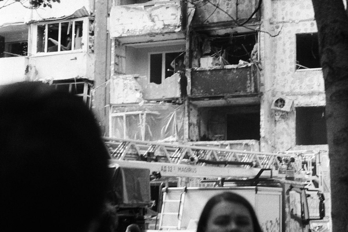 Damaged apartment building with a fire truck nearby