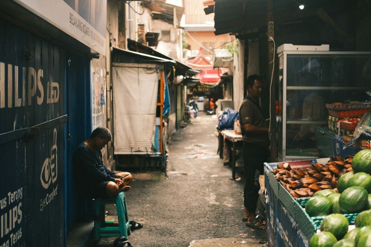 Narrow alleyway market with people and produce