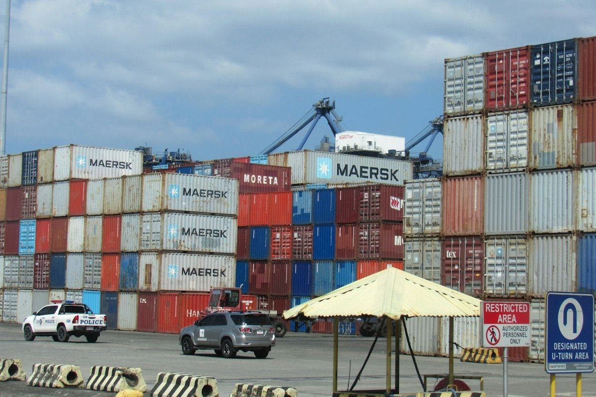 Stacked shipping containers at a busy port terminal
