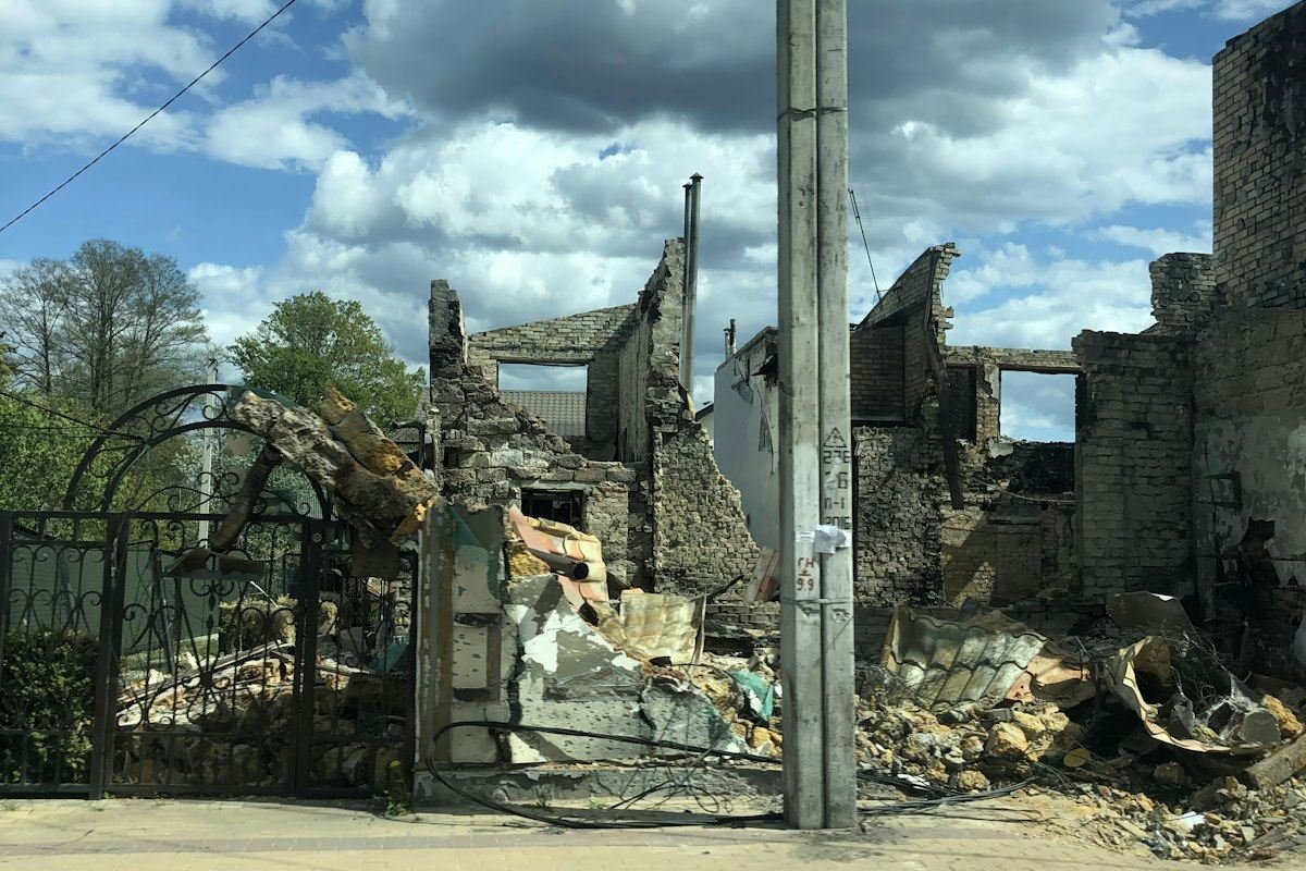 Destroyed building with rubble under a cloudy sky