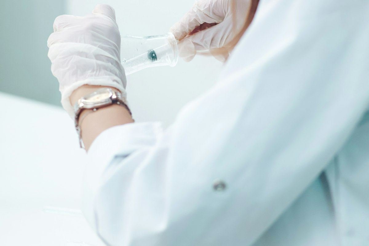 Scientist in lab coat prepares medical sample