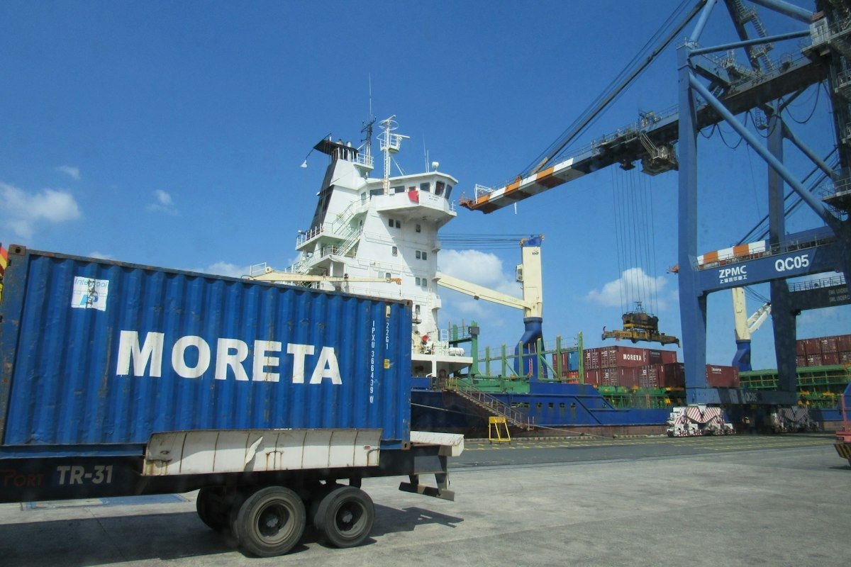 A large cargo ship is being loaded at a port