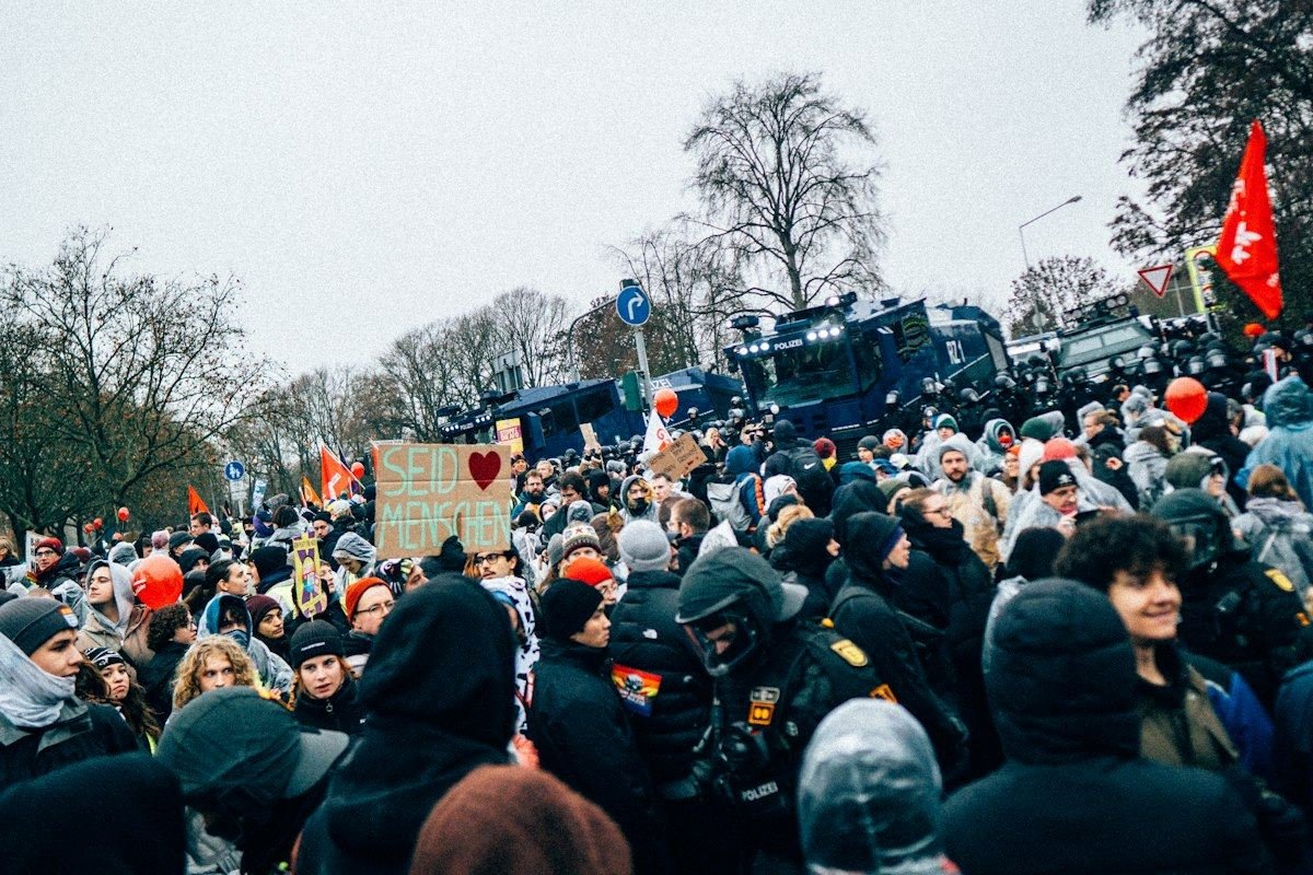 Crowd of people with police in background