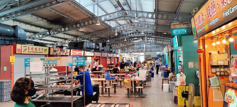 Food stalls and communal dining tables at a hawker centre in Singapore