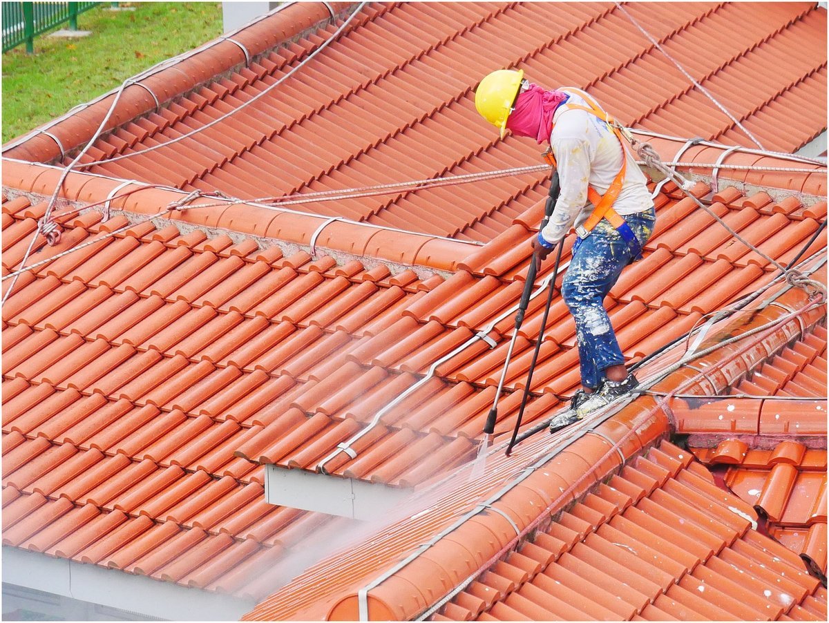 A manual worker in a hard hat and safety harness at work in Singapore