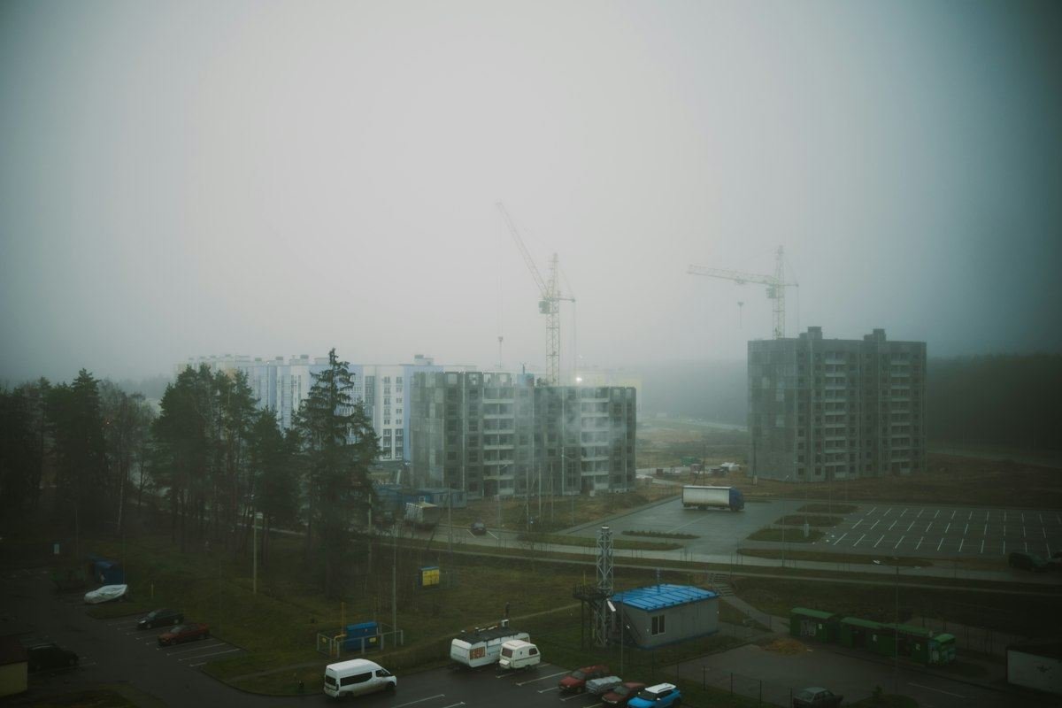 Construction site with cranes on a foggy day