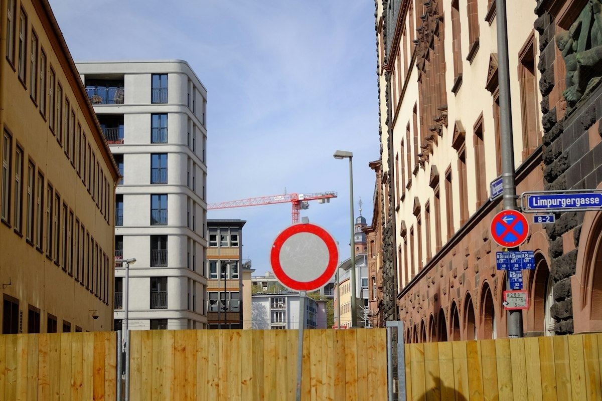 Construction site with barriers and buildings under blue sky