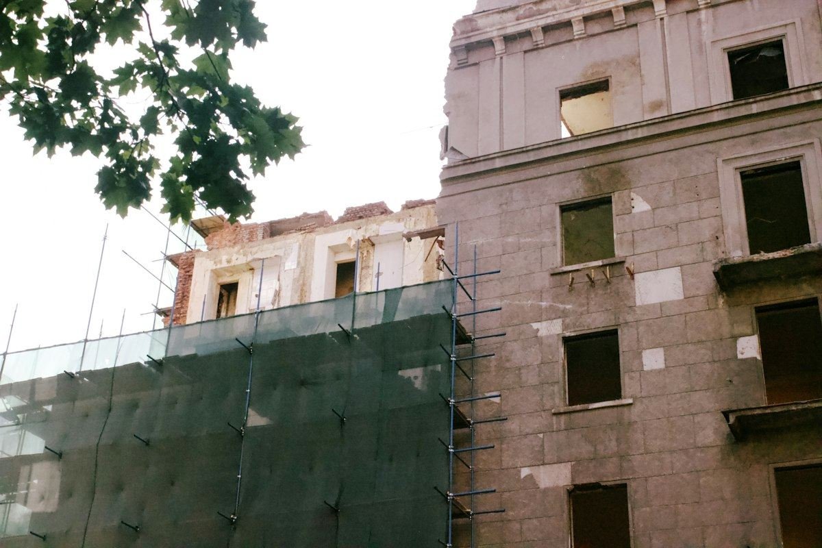 Building under construction with scaffolding and netting